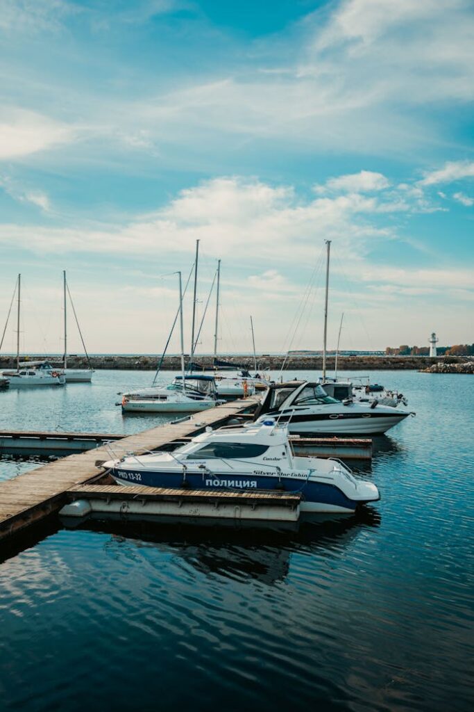 Explore a peaceful marina scene with various boats docked under a vibrant blue sky.